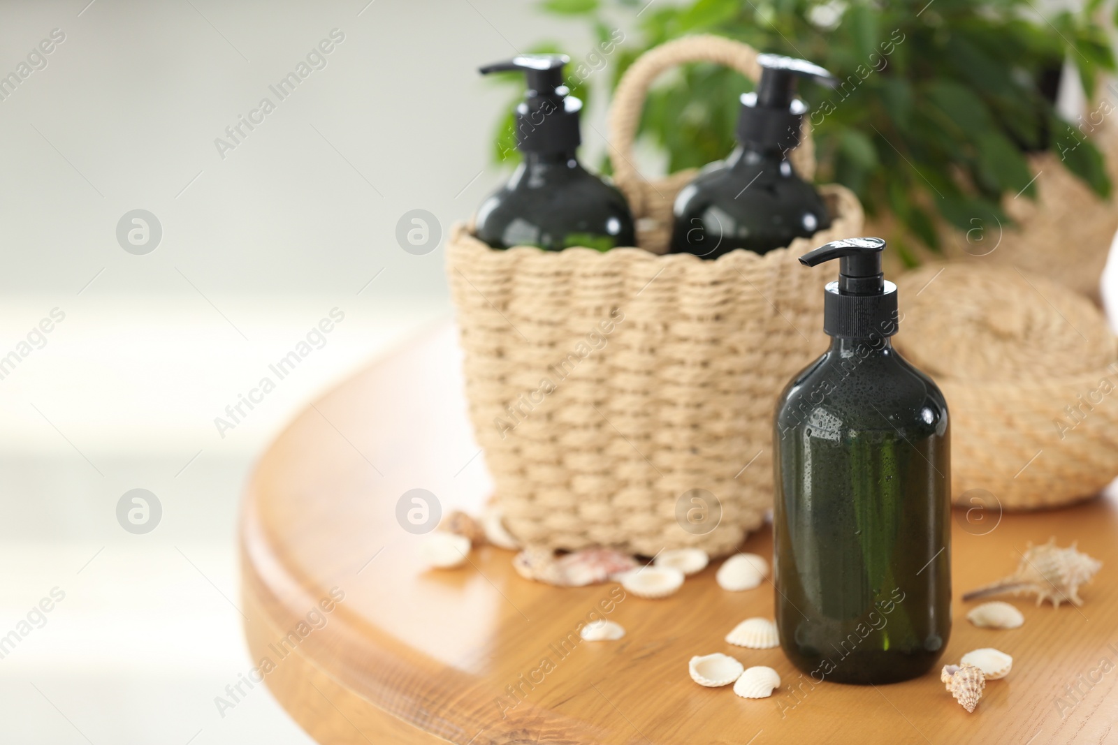 Photo of Soap dispensers and wicker basket on wooden table. Space for text