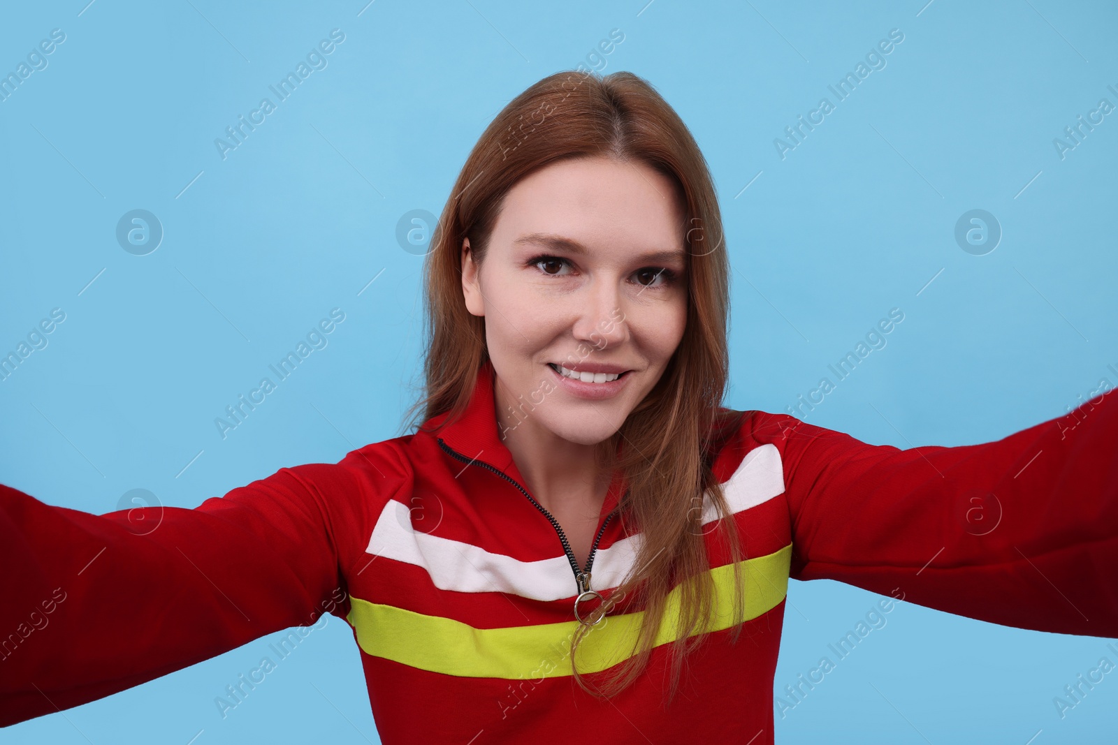 Photo of Beautiful woman taking selfie on light blue background