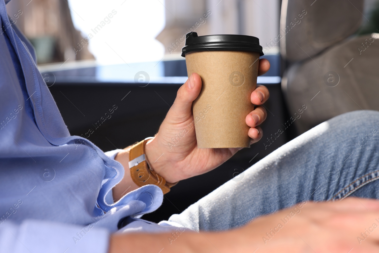 Photo of Coffee to go. Man with paper cup of drink in car, closeup