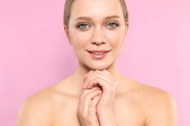 Portrait of young woman with beautiful face on pink background, closeup