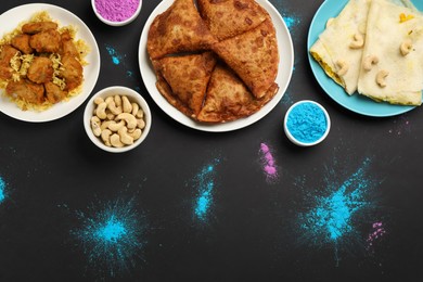 Photo of Traditional Indian food and color powders on black background, flat lay. Holi festival celebration
