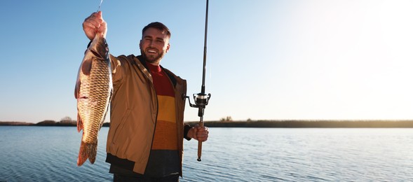 Image of Fisherman holding fishing rod and catch at riverside, space for text. Banner design