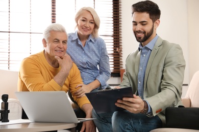 Male notary working with mature couple in office