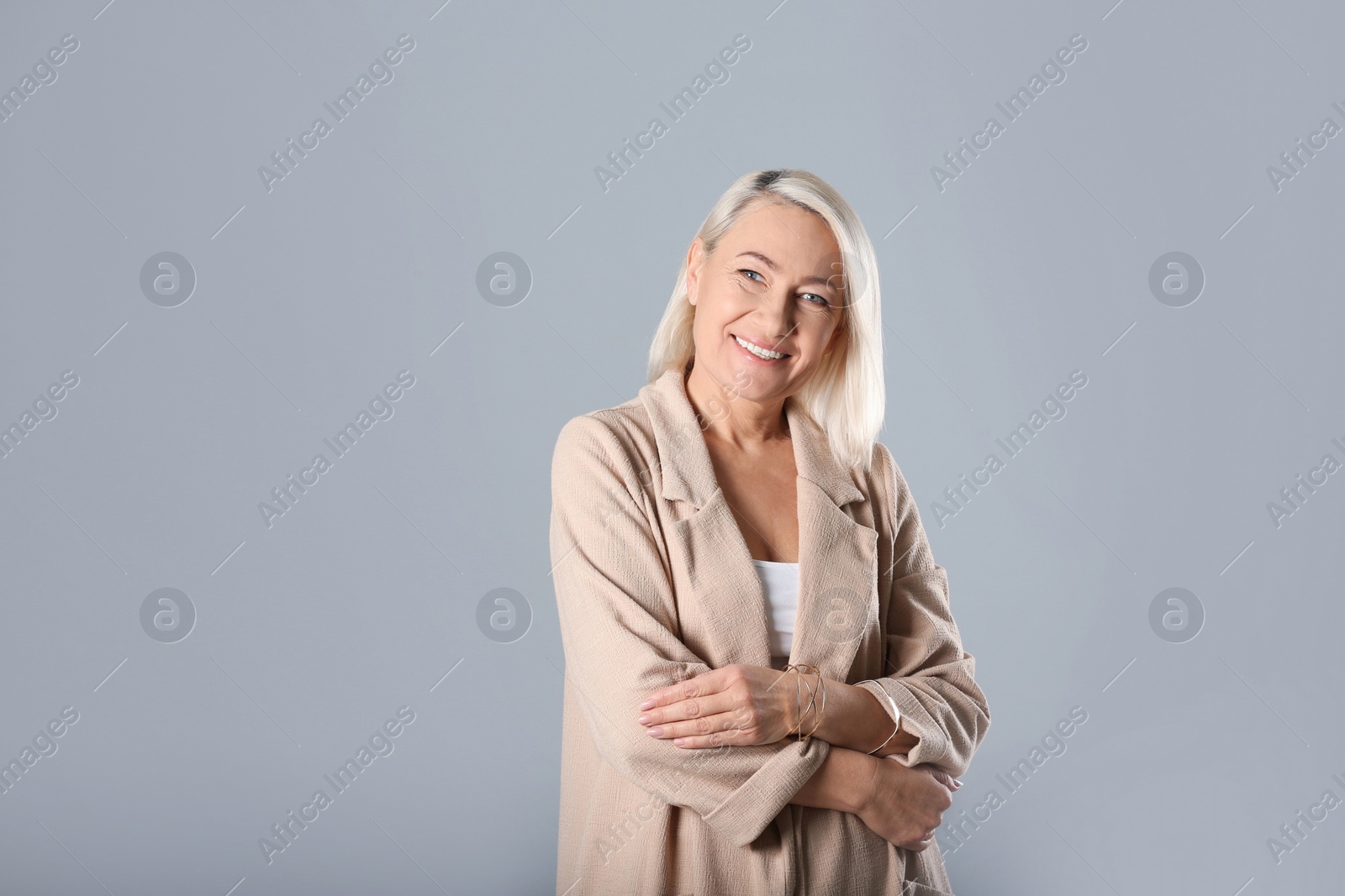 Photo of Portrait of beautiful mature woman on grey background. Space for text