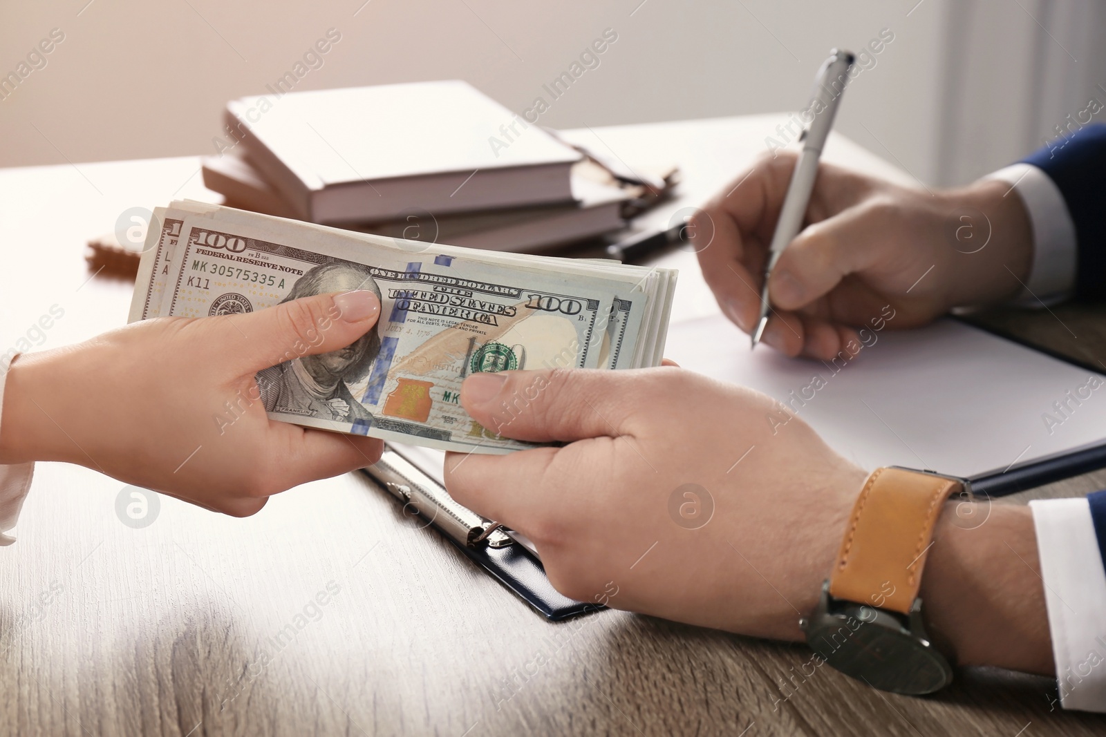 Photo of Woman giving bribe to man at table in office, closeup