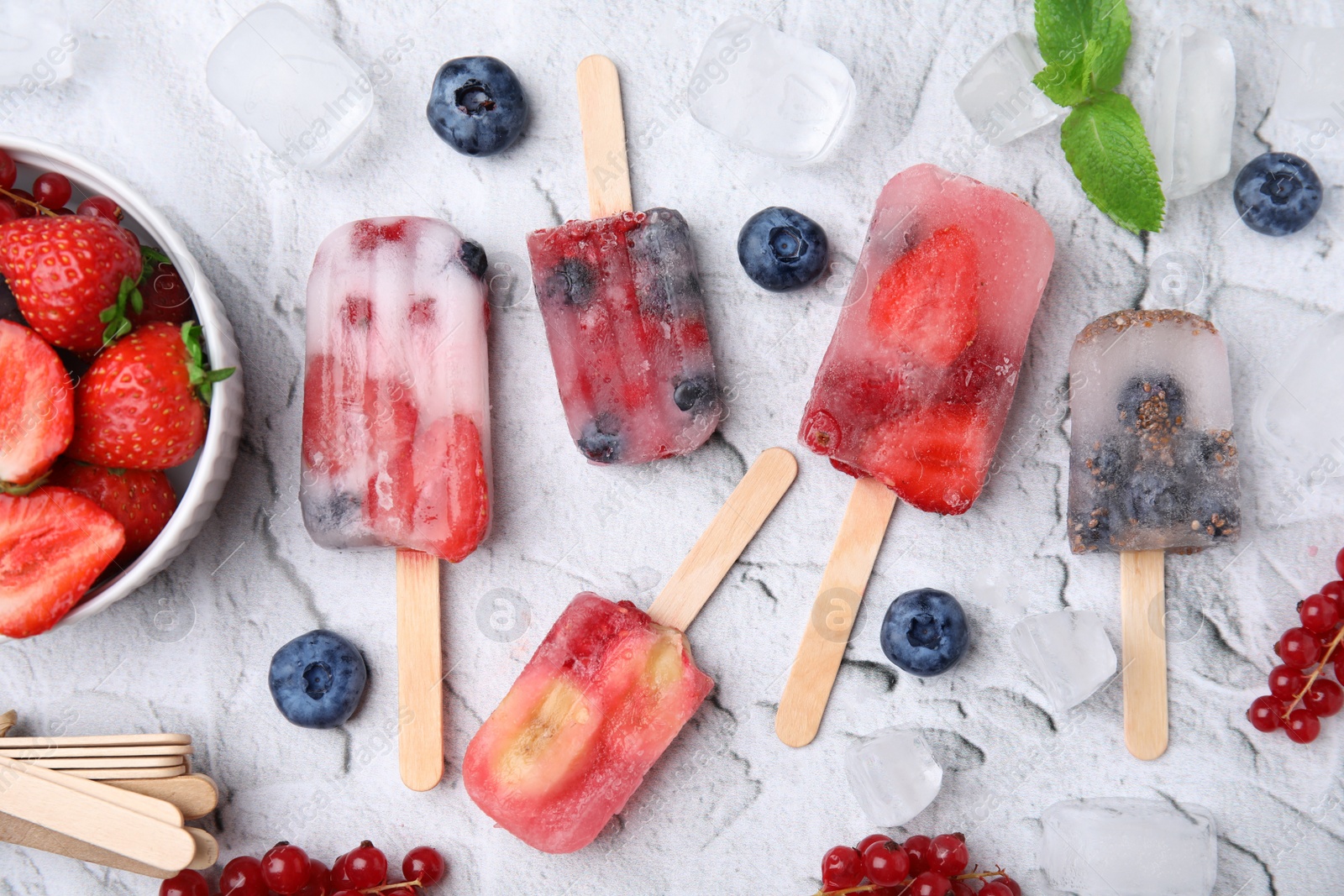 Photo of Flat lay composition with fruit and berry ice pops on light table