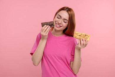 Photo of Young woman with pieces of tasty cake on pink background