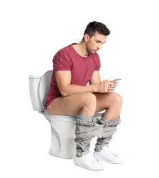 Photo of Man with smartphone sitting on toilet bowl, white background