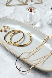 Photo of Different elegant bijouterie on white marble table