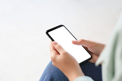 Photo of Closeup view of woman with smartphone indoors. Space for text