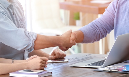 Photo of Mature manager and client shaking hands in office. Consulting service concept