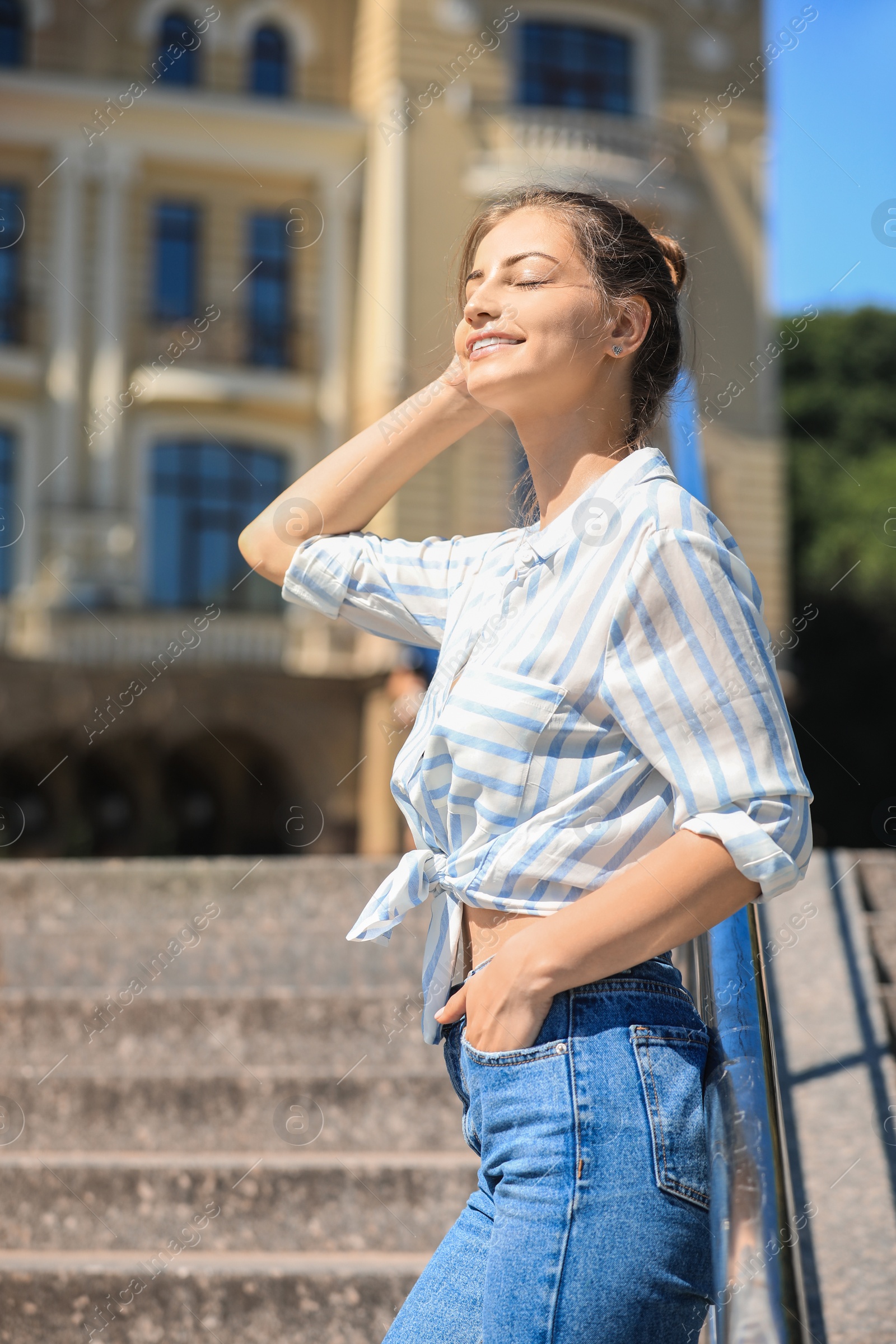 Photo of Young smiling woman outdoors on sunny day