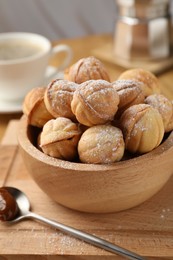 Photo of Bowl of delicious nut shaped cookies on wooden table