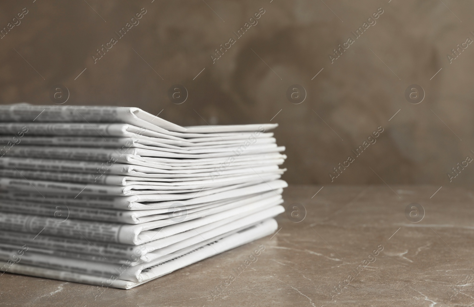 Photo of Stack of newspapers on marble table. Journalist's work