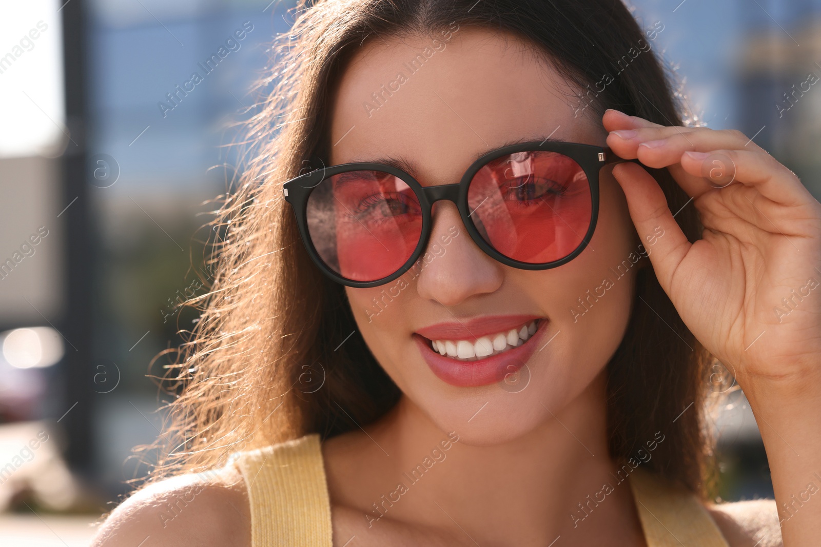 Photo of Beautiful smiling woman in sunglasses outdoors on sunny day