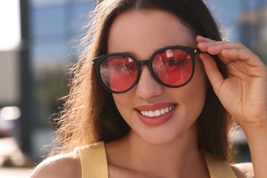 Photo of Beautiful smiling woman in sunglasses outdoors on sunny day