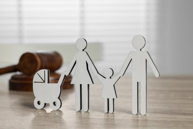 Photo of Family law. Figure of parents with children and gavel on light wooden table
