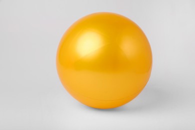 Photo of Orange inflatable beach ball on white background