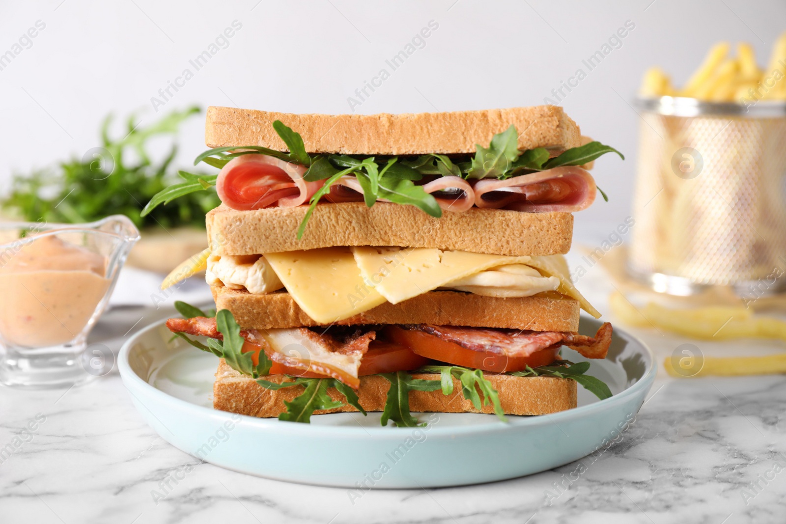 Photo of Tasty sandwich with chicken, ham and bacon served on white marble table