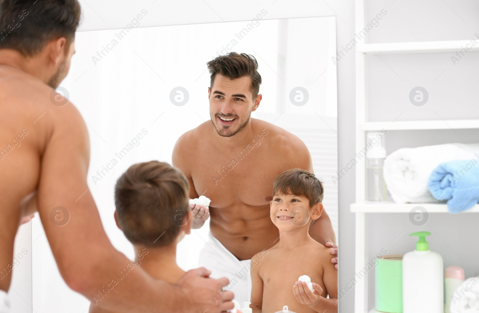 Photo of Father and son having fun while applying shaving foam in bathroom