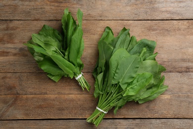 Fresh green sorrel leaves on wooden table, flat lay