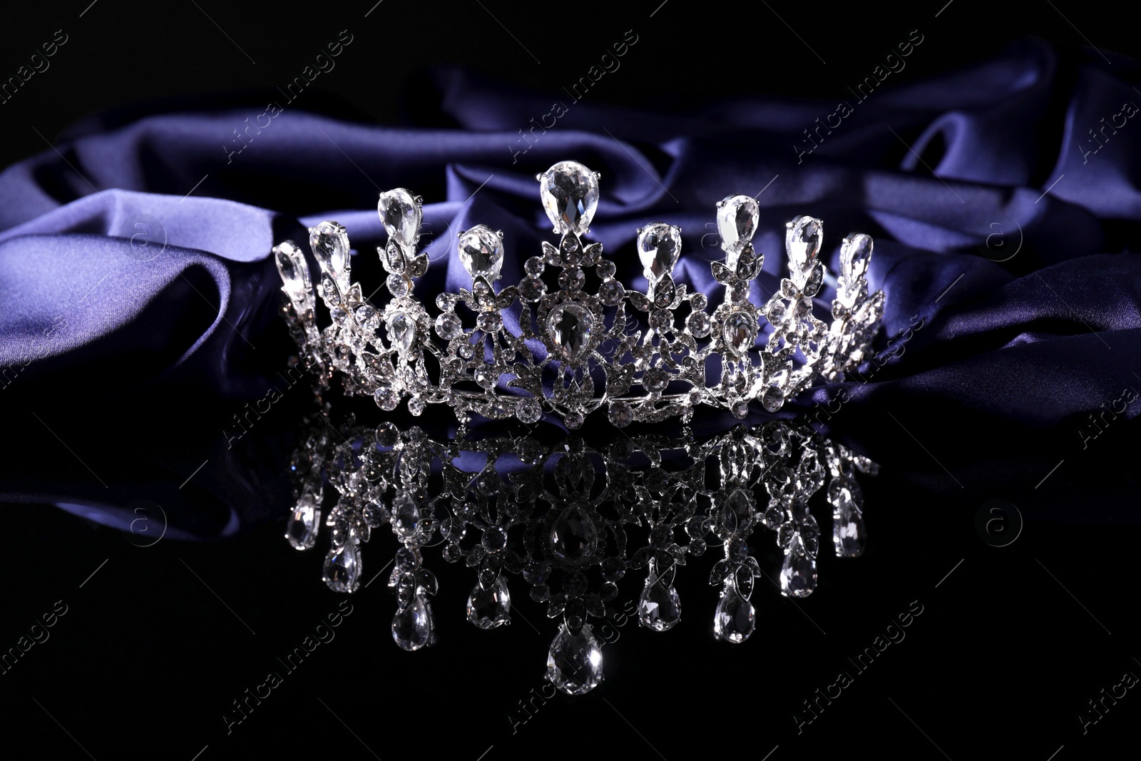 Photo of Beautiful silver tiara with diamonds on dark mirror surface