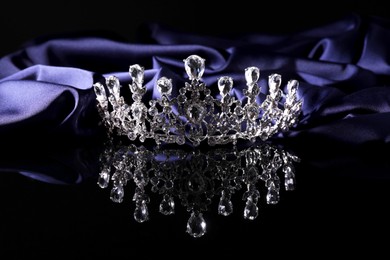 Beautiful silver tiara with diamonds on dark mirror surface