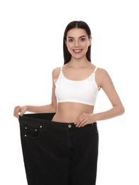 Photo of Young woman wearing big jeans after weight loss on white background