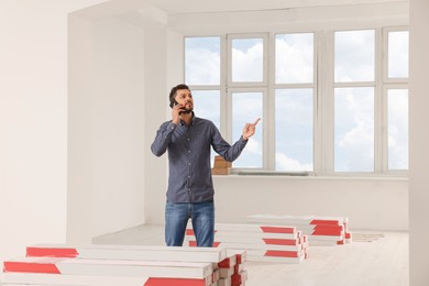 Man talking on phone in apartment during repair