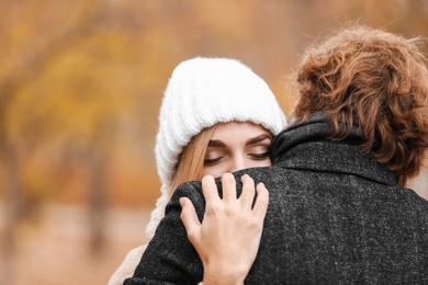 Photo of Young romantic couple hugging outdoors on autumn day