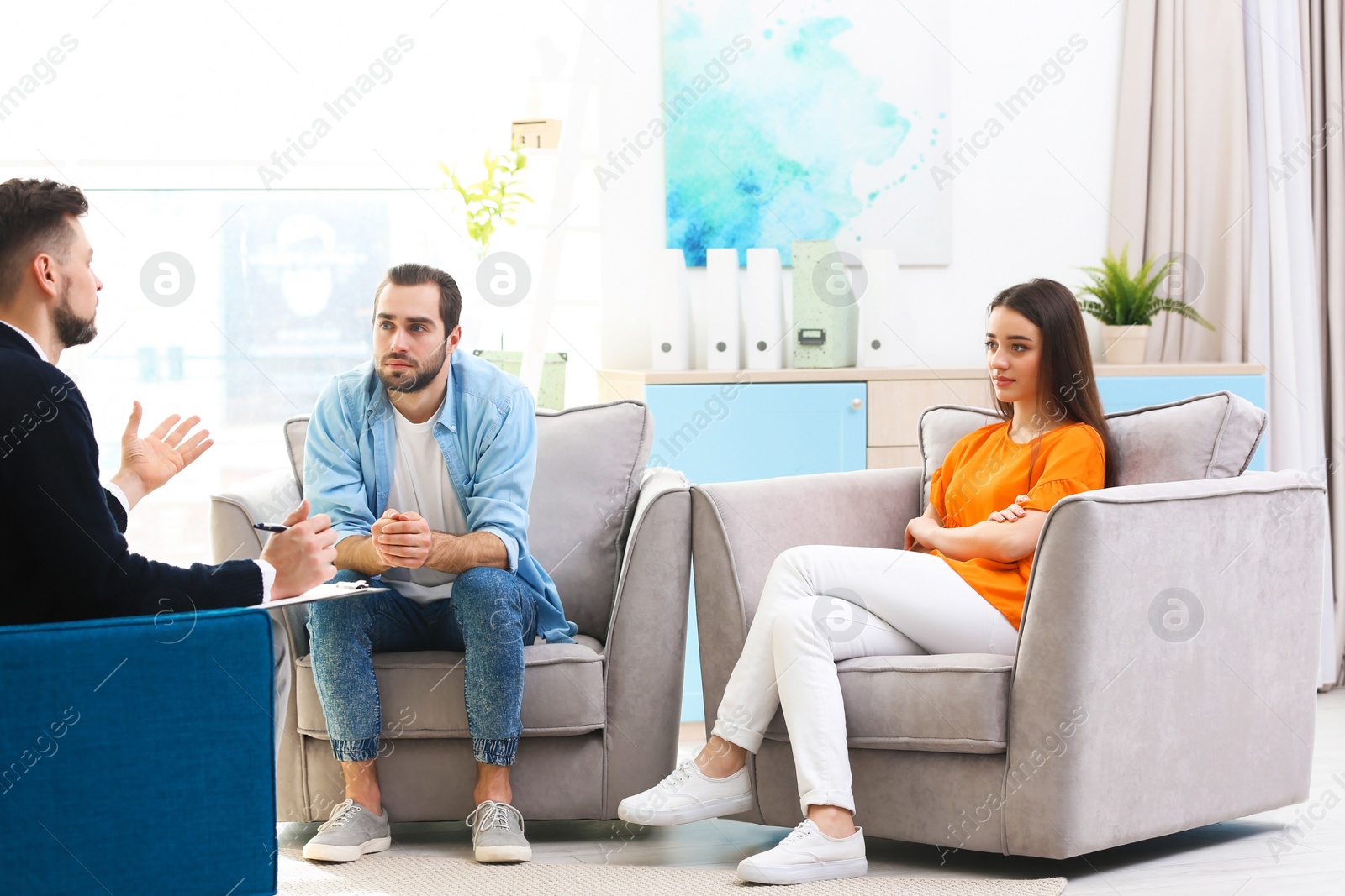 Photo of Family psychologist working with young couple in office