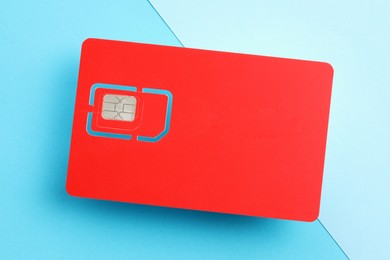 Photo of Red SIM card on color background, top view