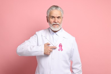 Photo of Mammologist with pink ribbon on color background. Breast cancer awareness