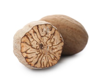 Photo of Whole and cut nutmeg seeds isolated on white