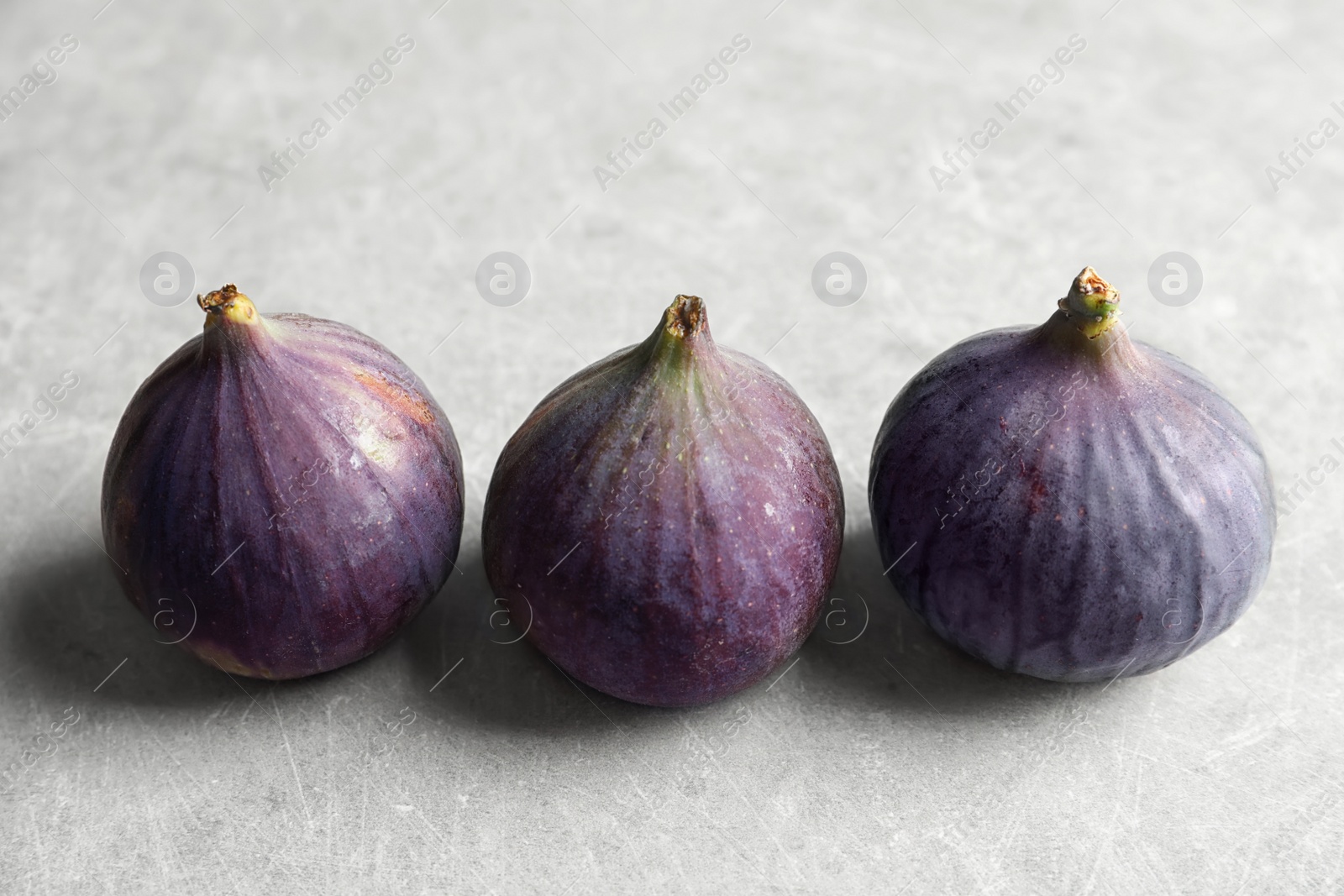 Photo of Fresh ripe figs on gray background. Tropical fruit