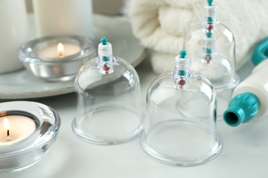 Photo of Plastic cups on white table, closeup. Cupping therapy