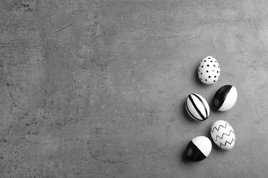 Painted Easter eggs on grey background, flat lay with space for text