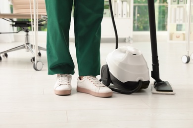 Janitor and professional steam cleaner indoors, closeup