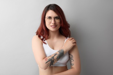 Portrait of beautiful tattooed woman on gray background