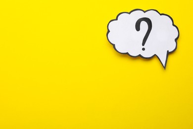 Photo of Paper speech bubble with question mark on yellow background, top view. Space for text