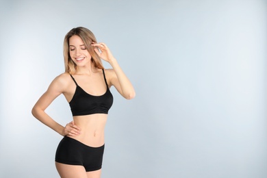 Photo of Young slim woman on light background, space for text. Perfect body