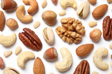 Photo of Different delicious nuts on white background, flat lay