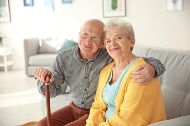 Photo of Elderly couple sitting on couch in living room