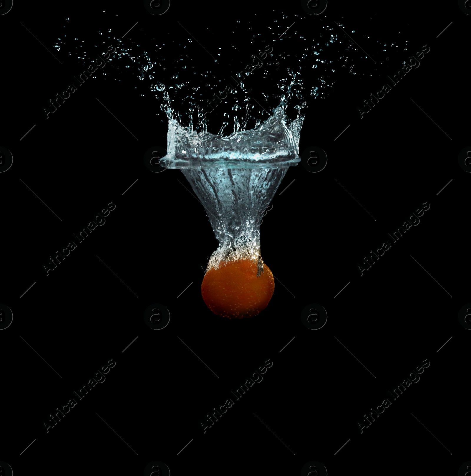 Photo of Tangerine falling down into clear water against black background