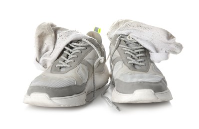 Photo of Sneakers with dirty socks on white background