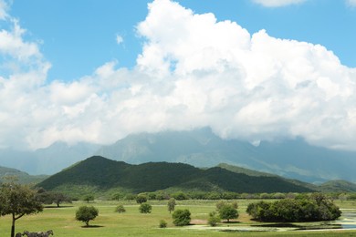 Picturesque view of mountains and green meadow