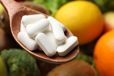 Photo of Dietary supplements. Spoon with pills over food products, closeup