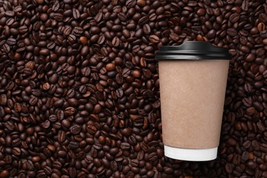 Photo of Coffee to go. Paper cup on roasted beans, top view and space for text