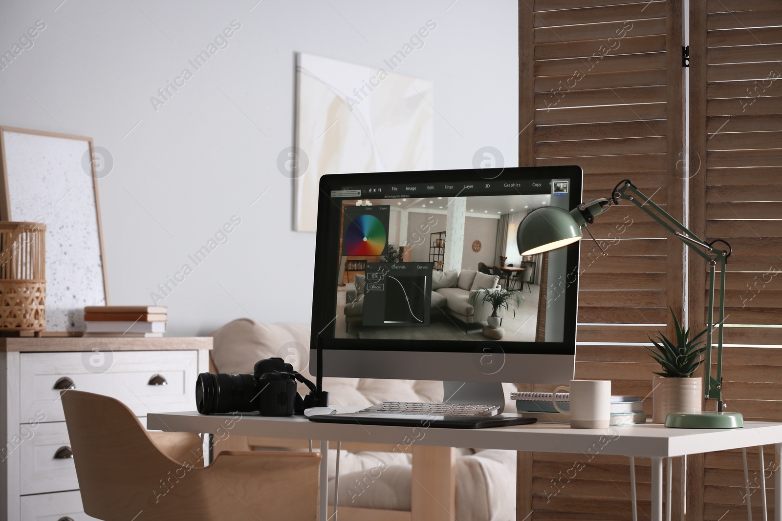 Photo of Retoucher's workplace. Computer with photo editor application, camera and graphic tablet on table in office