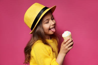 Photo of Adorable little girl with delicious ice cream against color background